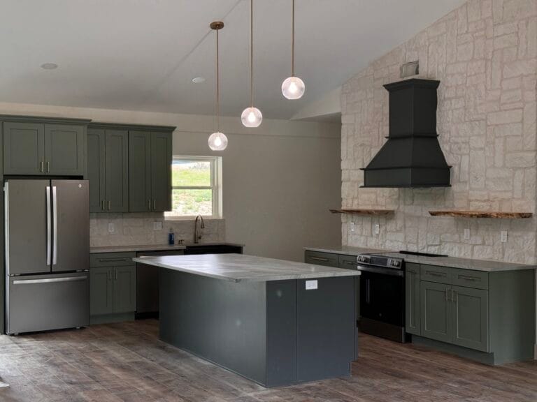 Open-concept kitchen featuring sage green cabinetry, matte quartz countertops, and wood-look flooring.